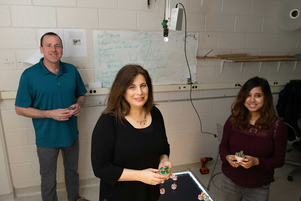 Dana Randall, Daniel Goldman, and Bahnisikha Dutta work together on creating magnetic robots. This photo was taken in 2019 at Georgia Tech as part of a previous research study (Credit: Allison Carter, Georgia Tech)