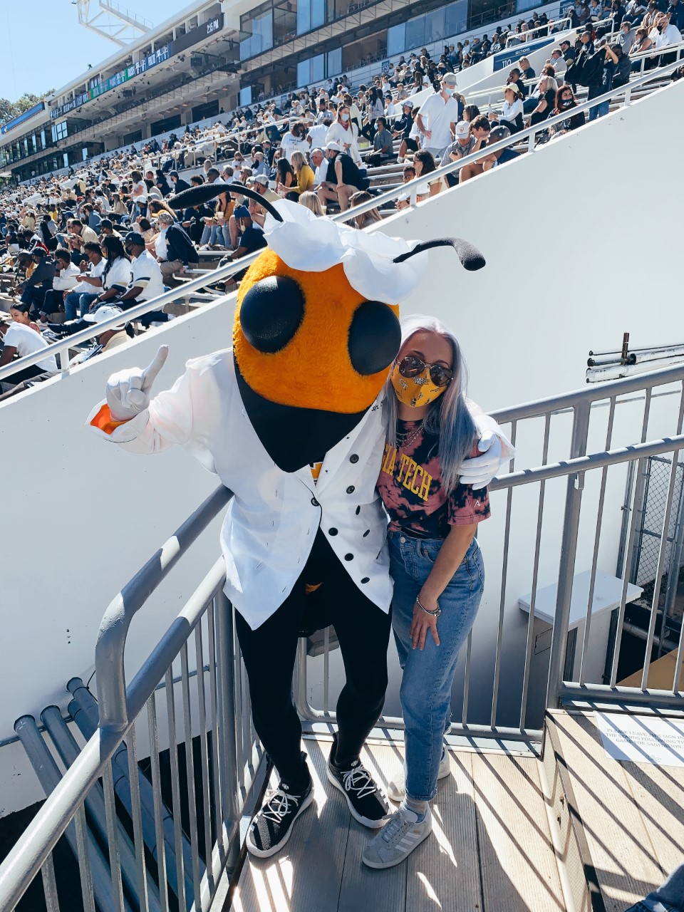 Jess Eskew, Georgia Tech Physics student, poses with Buzz at a football game.