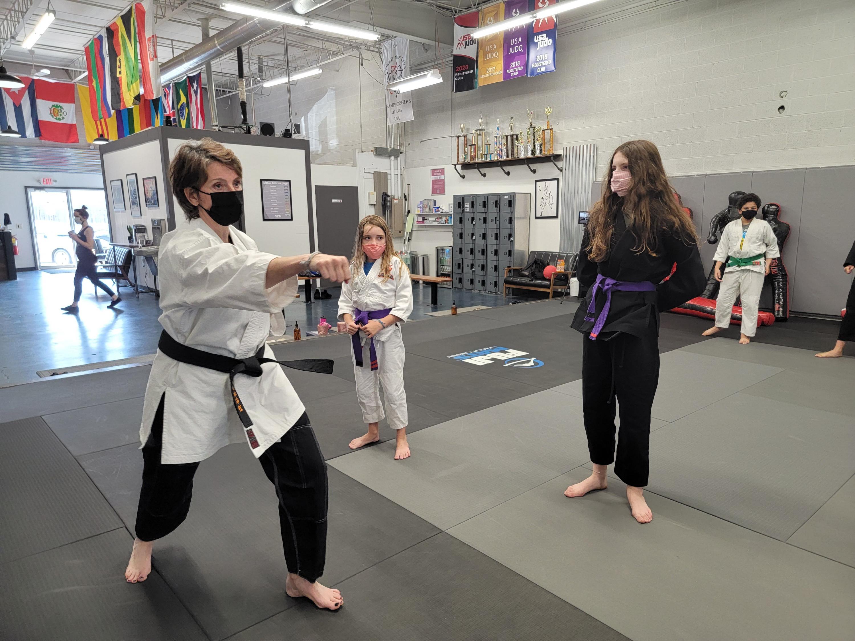 Pamela Pollet (left) demonstrates punching technique to her martial arts students (Credit: Evolution X)