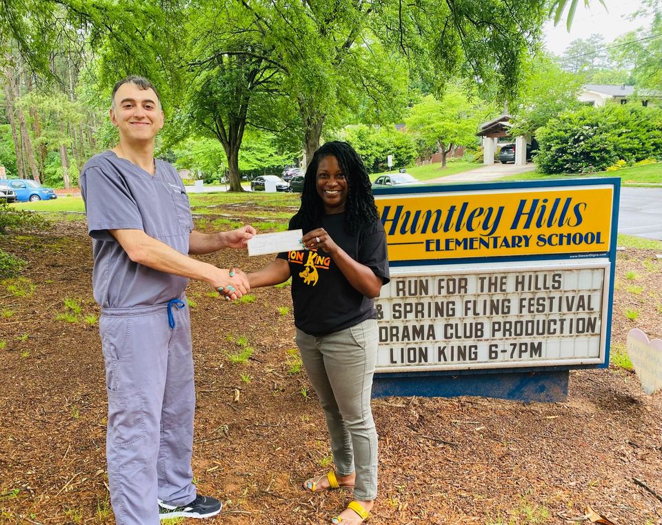 Brookhaven Family Dentistry owner Dr. Andrew Kokabi presents Huntley Hills Elementary Principal Mia Ford with a check from his practice's 