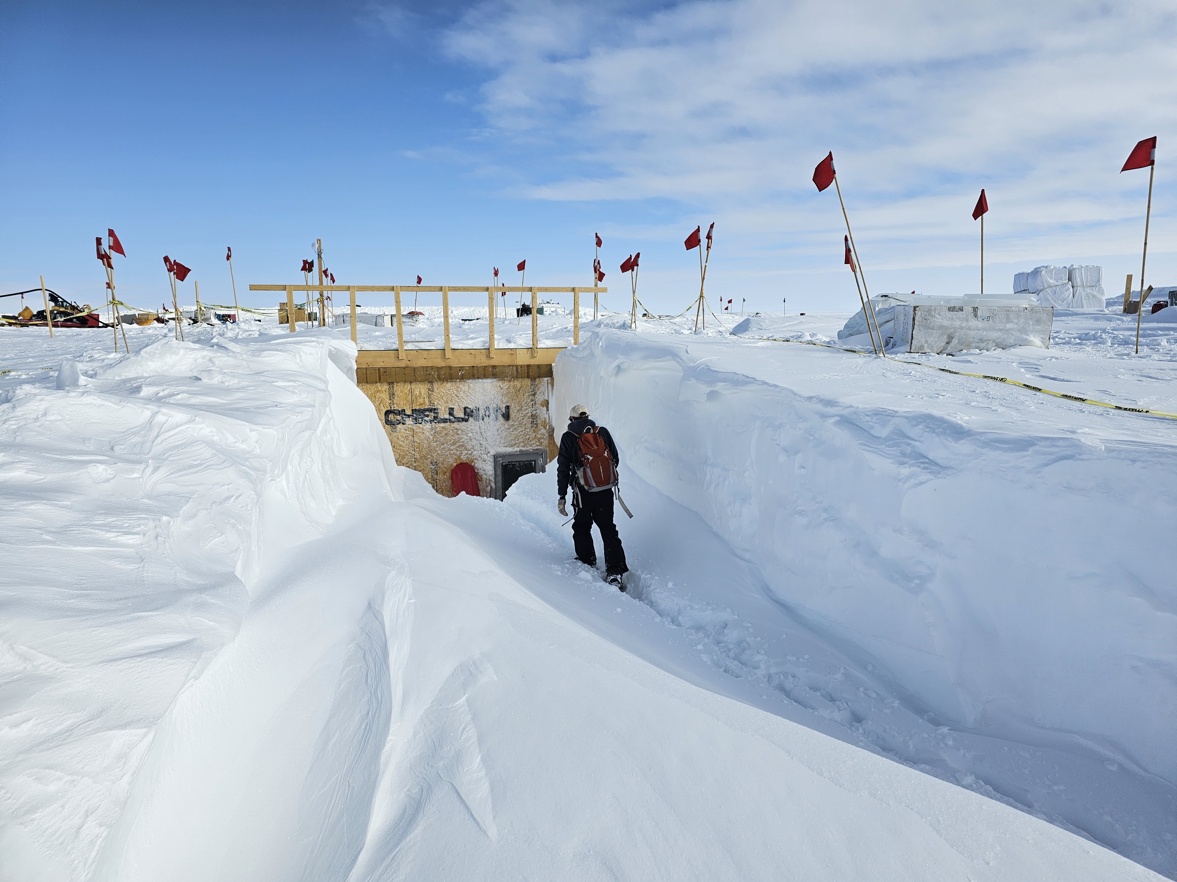 Nathan Chellman walking into the research trench over drifted snow.