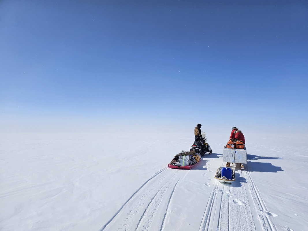 Moore and the research team traveling to a remote field site to collect ice core data.