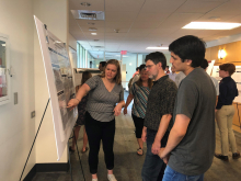 Rachel Walker (center) explains her Summer REU 2019 math research (Photo by Yasmine Bassil) Rachel Walker (center) explains her Summer REU 2019 math research (Photo by Yasmine Bassil)