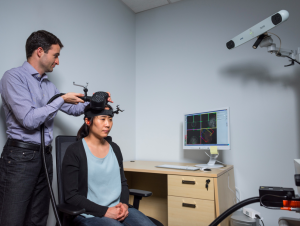School of Psychology Assistant Professor Dobromir Rahnev demonstrates the application of transcranial magnetic stimulation (TMS) in a Georgia Tech psychology research center with graduate student Ji-Won Jung. (Photo Georgia Tech/Rob Felt)