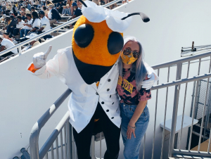 Jess Eskew, Georgia Tech Physics student, poses with Buzz at a football game.