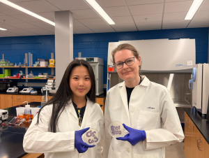 Grace Tang (Left) and Alison Onstine (Right) holding bacteria plates that spell "BIOL 4590" (Credit: Tang and Onstine)