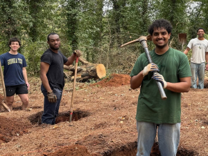 Benjamin Manoj (front) and other Yellow Jackets Against Poverty members dig holes for the foundation of a new homeless shelter.
