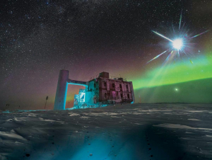 In this artistic composition, based on a real image of the IceCube Lab at the South Pole, a distant source emits neutrinos that are detected below the ice by IceCube sensors, called DOMs. (IceCube/NSF)