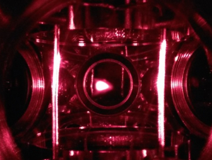 A closeup of the magnetic optical trap (MOT) in Colin Parker's quantum simulator. The glowing spot in the image center is the fluorescence from about 1 billion atoms cooled to less than a 1/1000 of a degree above absolute zero. (Photo Colin Parker)