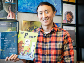 David Hu holding two popular science books he's authored.