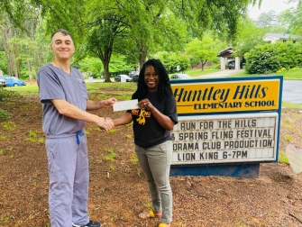 Brookhaven Family Dentistry owner Dr. Andrew Kokabi presents Huntley Hills Elementary Principal Mia Ford with a check from his practice's "Brighten Your Smile, Better Your World" campaign. (Photo Brookhaven Family Dentistry) 